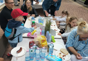 Dzieci przy stolikach grilowych.