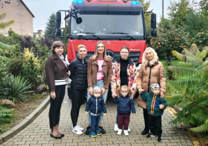 Panie z dziećmi na tle wozu strażackiego.