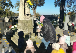 Dzieci na cmentarzu przy pomniku.