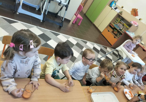 Dzieci przy stoliku degustuję soczek.