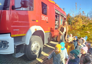 Dzieci oglądają wóz strażacki.