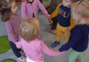 Dzieci tańczą w kółeczko na imprezie kolegi.