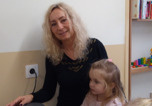 Dzieci z ciocią łączą składniki na pierniki.