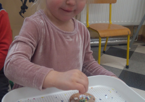 Dziecko dekoruje piernika.