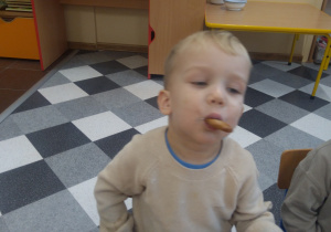 Chłopiec je pierniczka.