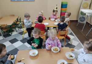 Dzieci przy stolikach podczas urodzinowego poczęstunku.