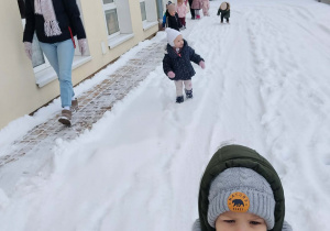 Dzieci bawią się na śniegu.