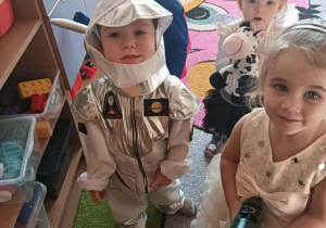 Dzieci w przebraniach tańczą na balu.