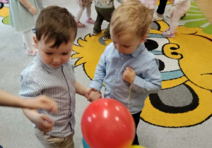 Dzieci bawią się balonami z jubilatem.