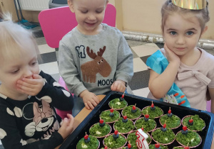 Dzieci wokół tacy babeczek.