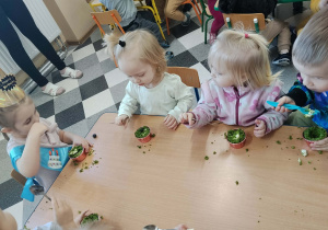 Dzieci przy stolikach podczas poczęstunku urodzinowego.