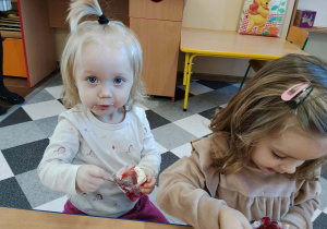 Dzieci jedzą deserki urodzinowe.