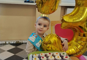 Jubilat z deserkami urodzinowymi.