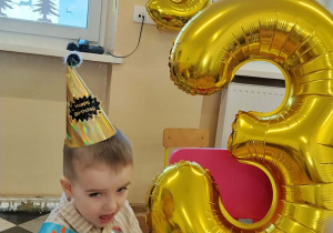 Dzieci jedzą deserki urodzinowe.