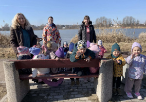 Dzieci spacerują nad zalewem.