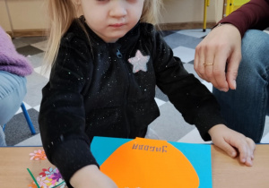 Dzieci przy stolikach robią wazoniki.