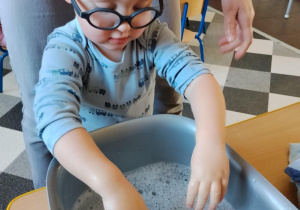 Dzieci malują paluszkami cebulki kwiatów.