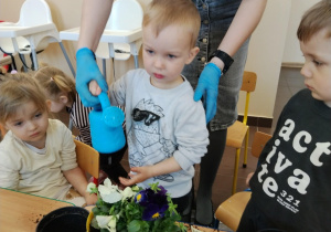 Dzieci sadzą kwiatki.