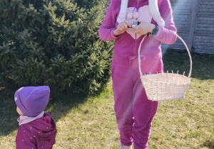 Dzieci wraz z zającem szukają upominków na placu żłobkowym.