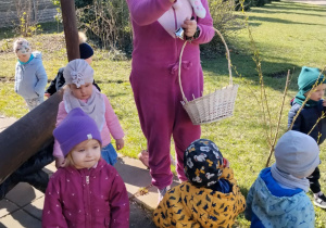 Dzieci wraz z zającem szukają upominków na placu żłobkowym.