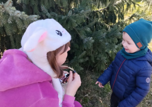 Dzieci wraz z zającem szukają upominków na placu żłobkowym.