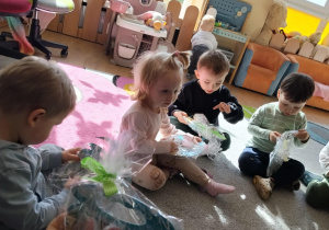 Dzieci dostają upominki od zająca wielkanocnego.