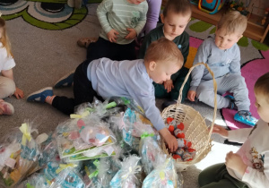 Dzieci dostają upominki od zająca wielkanocnego.