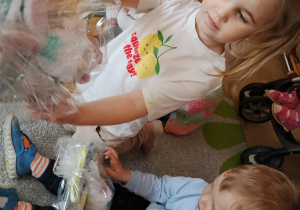 Dzieci dostają upominki od zająca wielkanocnego.