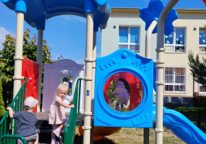 Dzieci bawią się na nowym kolorowym placu zabaw.